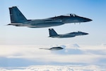 Three military planes fly in the sky.