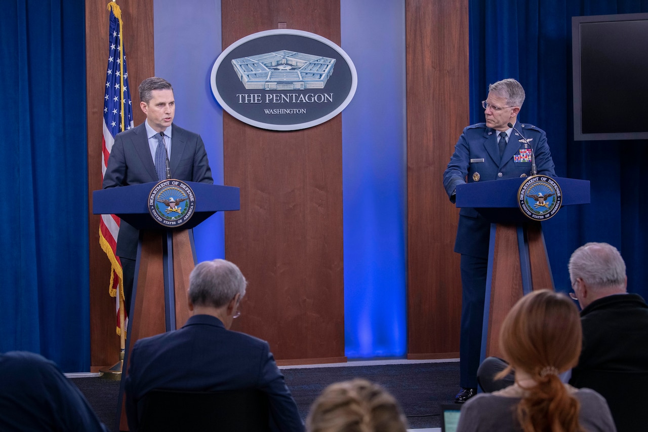 A civilian and an Air Force general brief reporters.