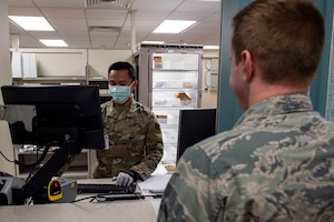 Photo of an Airman locating a patient’s prescription.