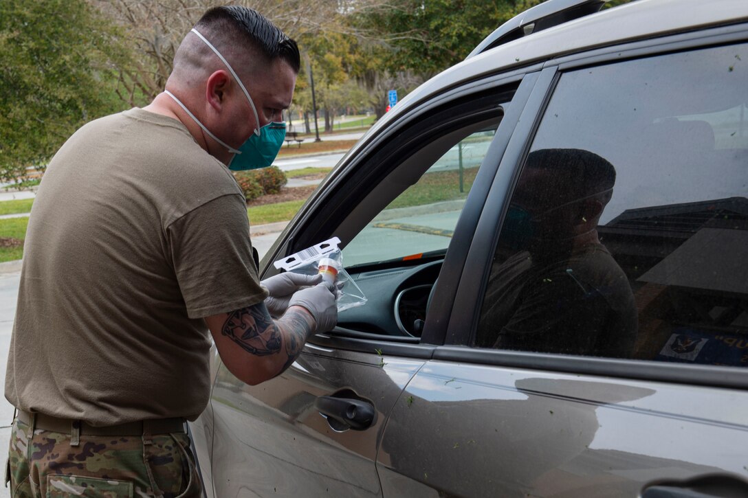 Photo of an Airman delivering a prescription during a pick-up line.