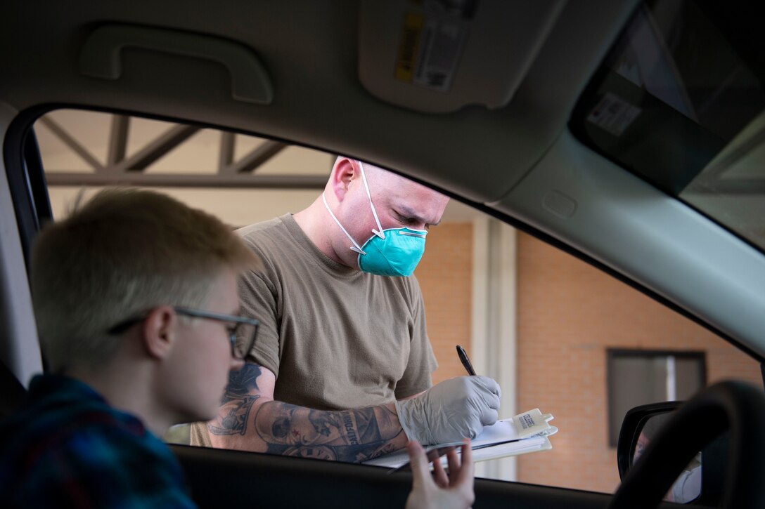 Photo of an Airman assisting a patient during a prescription pick-up line.