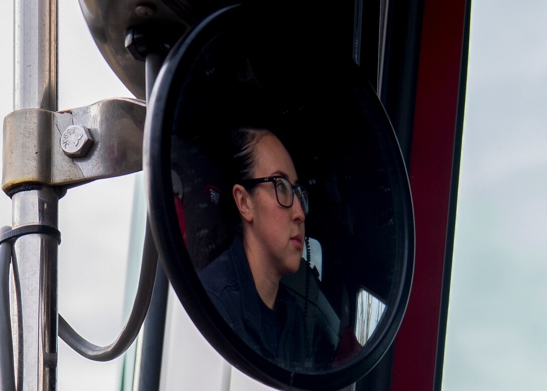 Firefighter sits in her firetruck.