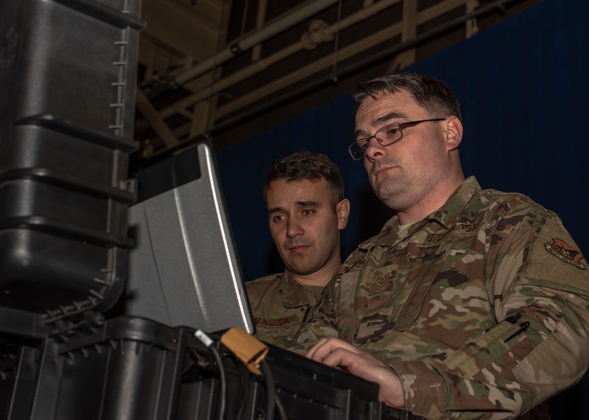 U.S. Air Force Tech. Sgt. Manuel Fralick, left, an outbound cargo NCO in charge, and Staff Sgt. James Davis, a cargo movement supervisor both with the 35th Logistics Readiness Squadron, review calculations at Misawa Air Base, Japan, March 13, 2020. The new laser profile system allowed the cargo deployment function to validate the measurements, weight and center of balance of cargo moves for exercises, deployments and day-to-day operations in an expedient matter, increasing work efficiency. (U.S. Air Force photo by Airman 1st Class China M. Shock)