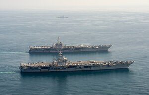 The aircraft carriers USS Dwight D. Eisenhower (CVN 69), front, and USS Harry S. Truman (CVN 75), and the guided-missile destroyer USS Lassen (DDG 82) transit the Arabian Sea March 18, 2020. The Harry S. Truman Carrier Strike Group is deployed to the U.S. 5th Fleet area of operations in support of naval operations to ensure maritime stability and security in the Central Region, connecting the Mediterranean and the Pacific through the western Indian Ocean and three strategic choke points.