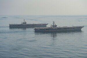 The aircraft carriers USS Dwight D. Eisenhower (CVN 69), front, and USS Harry S. Truman (CVN 75), center, and the guided-missile destroyer USS Lassen (DDG 82) transit the Arabian Sea March 18, 2020. The Harry S. Truman Carrier Strike Group is deployed to the U.S. 5th Fleet area of operations in support of naval operations to ensure maritime stability and security in the Central Region, connecting the Mediterranean and the Pacific through the Western Indian Ocean and three strategic choke points.