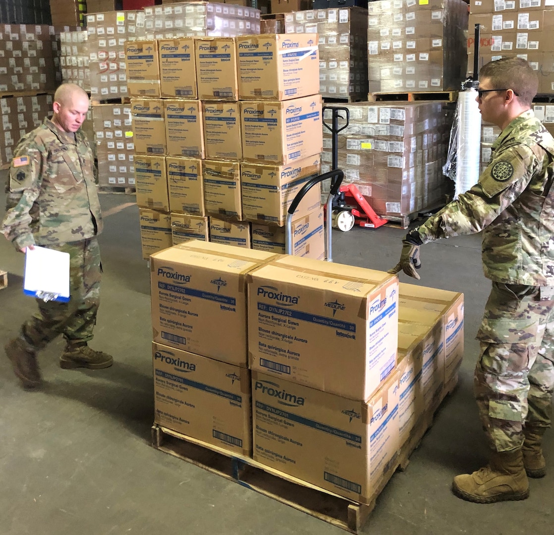 Soldiers from the Michigan National Guard assist Michigan Department of Health and Human Services with assembling and loading critical personal protective gear, such as gloves, gowns and face shields, March 18, 2020. Once packaged, MDHHS will deliver the supplies to local public health departments.
