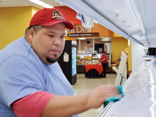 Albert Espinoza, Laughlin Air Force Base, Texas commissary meat department head, disinfects a store shelf at the store Mar. 19, 2020. In response to the outbreak in other parts of the country, Laughlin Air Force Base, Texas, has made modifications to its daily operations starting March 16 to keep the base operational while protecting the health and wellness of its Airmen, their families, the local community, and everyone who visit the base.