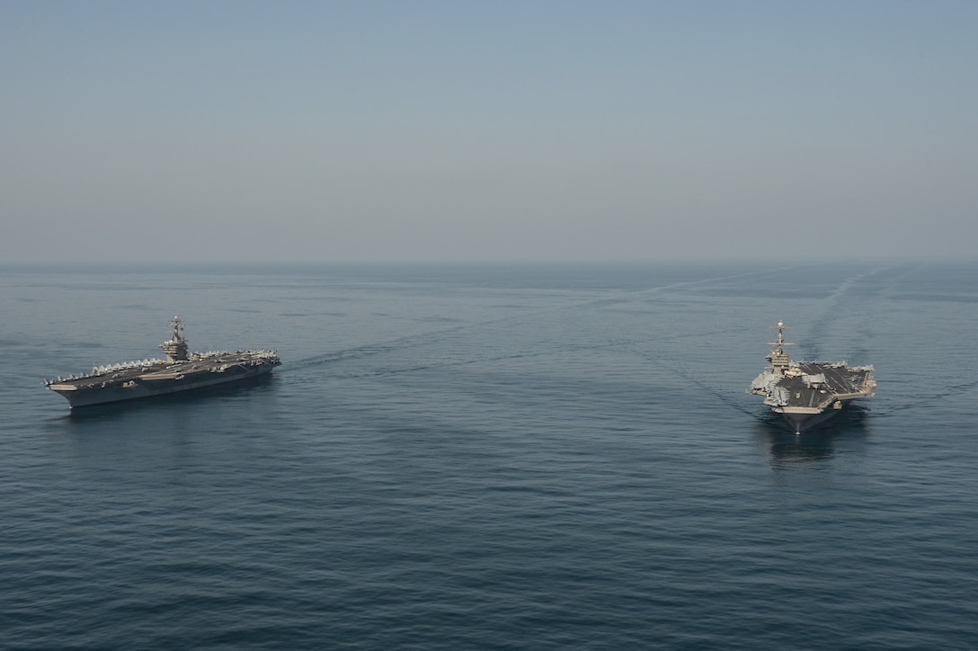 The aircraft carriers USS Dwight D. Eisenhower (CVN 69), left, and USS Harry S. Truman (CVN 75) transit the Arabian Sea March 18, 2020. The Harry S. Truman Carrier Strike Group is deployed to the U.S. 5th Fleet area of operations in support of naval operations to ensure maritime stability and security in the Central Region, connecting the Mediterranean and the Pacific through the Western Indian Ocean and three strategic choke points.