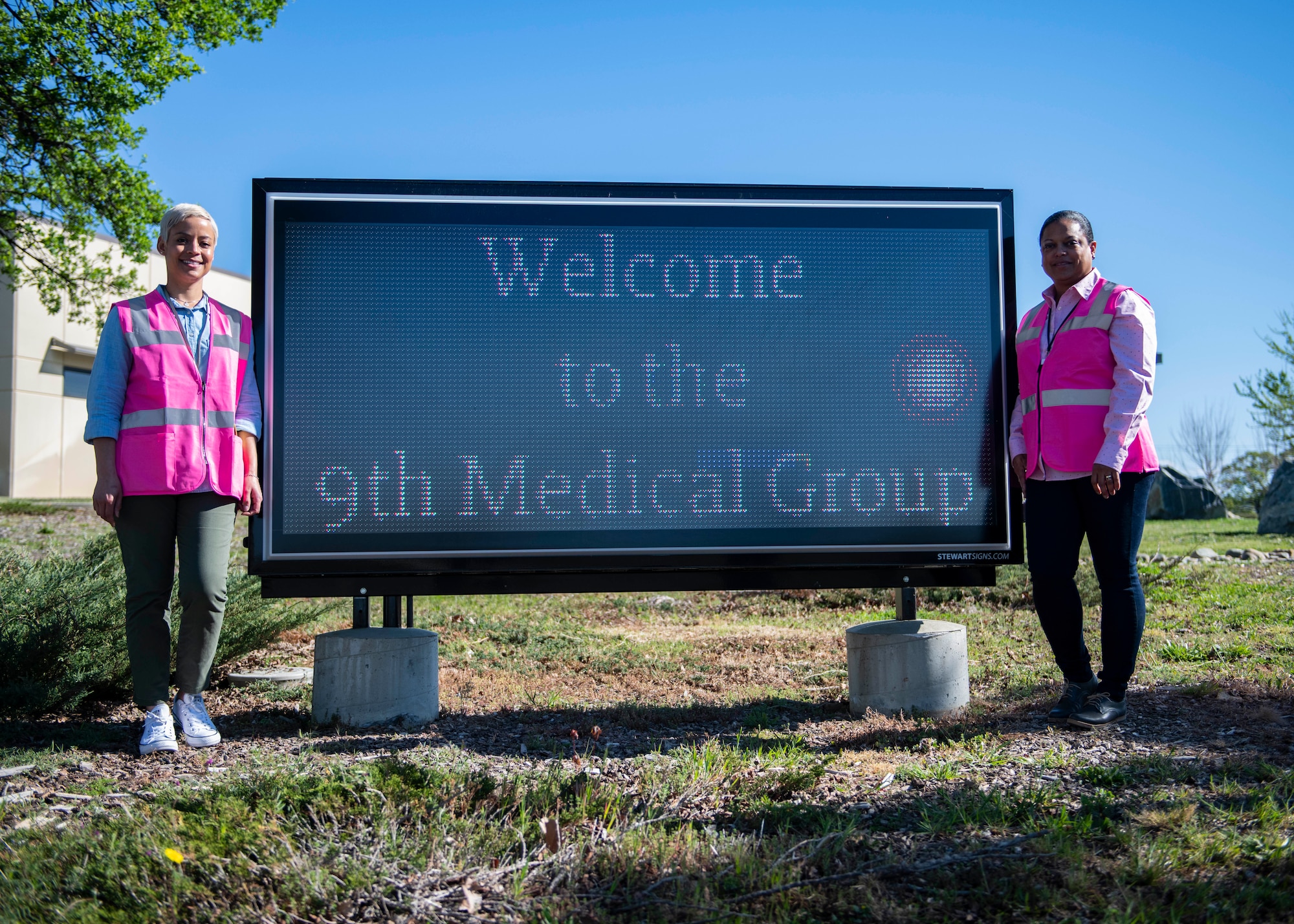 Lynn Bergmann, 9th Medical Group patient safety program coordinator, and Denise Ross, 9th MDG Patient Advocate, pose for a photo in front of the clinic’s marquee on Beale Air Force Base, California.