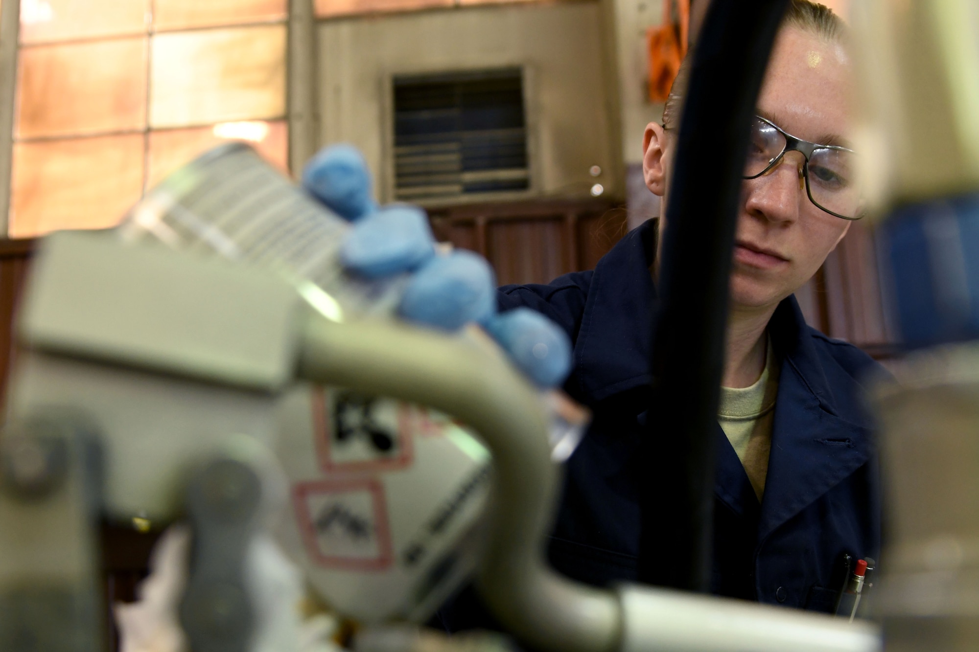 A photo of an airman changing oil