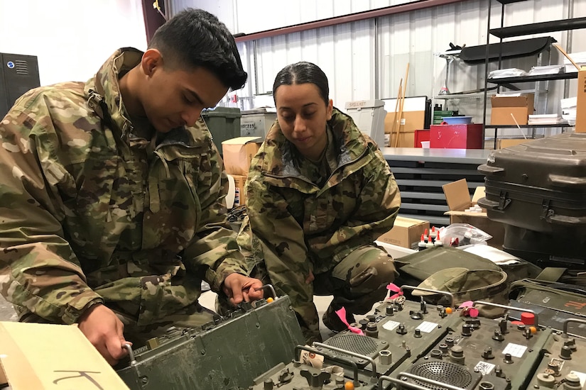 Two people look over radios.