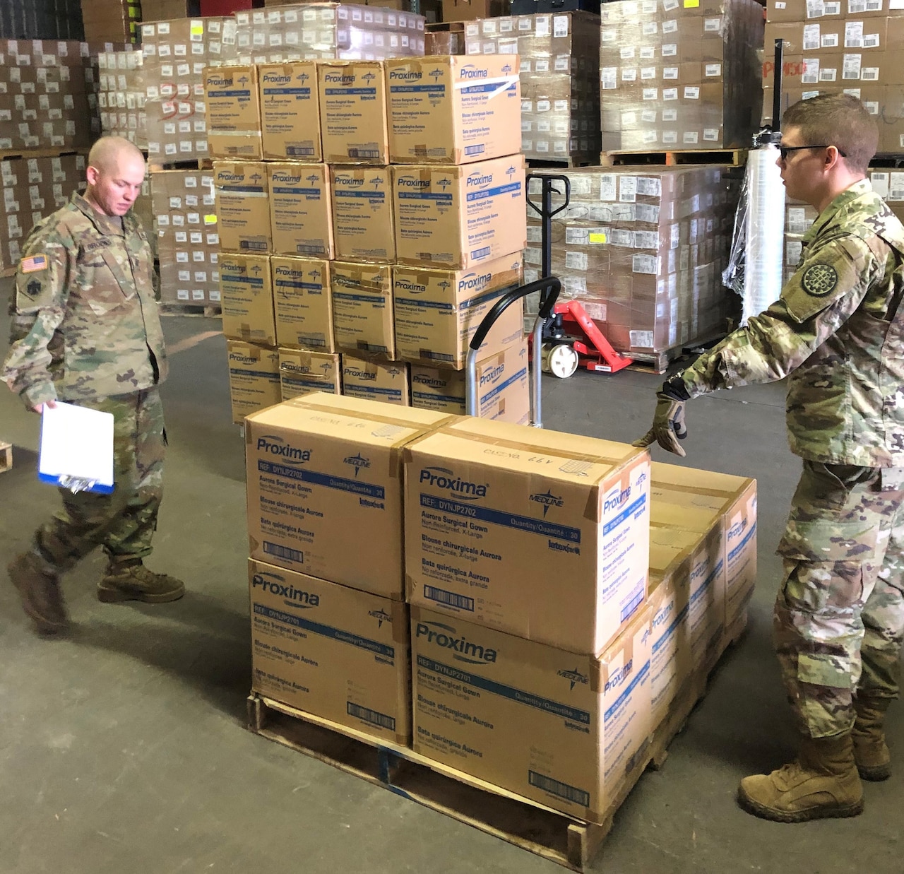 Men use a hand truck to move stacks of boxes