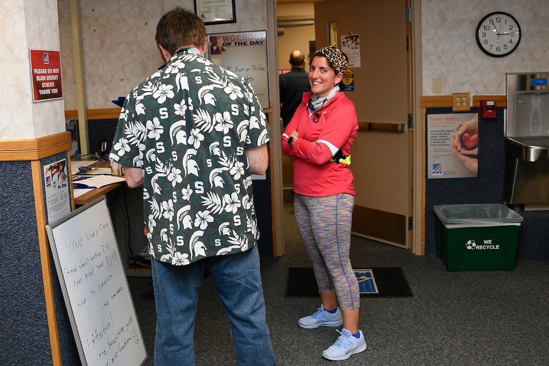 Runner (right) Jessica Waynick discusses her March 13 run for Pi Day with other Fitness Center patrons.