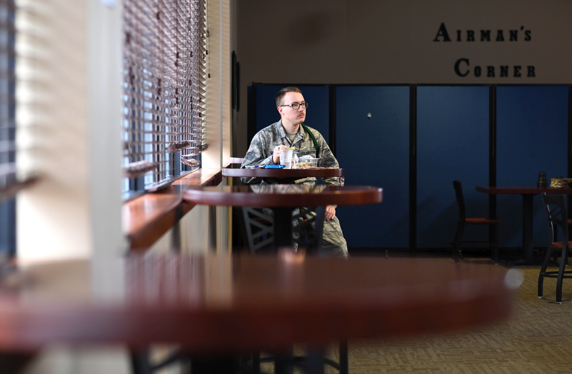 Airman 1st Class Henry Kosmicki, 373rd Training Squadron Detachment 8 student, eats lunch at the Chisholm Trails Inn Dining Facility March 18, 2020, at McConnell Air Force Base, Kansas. In efforts to support social distancing, the dining facility has decreased its maximum seating capacity to 37 seats. Personnel eligible to enter the facility has also been limited to three categories: uniformed service members, meal card holders and emergency services personnel. (U.S. Air Force photo by Airman 1st Class Nilsa E. Garcia)