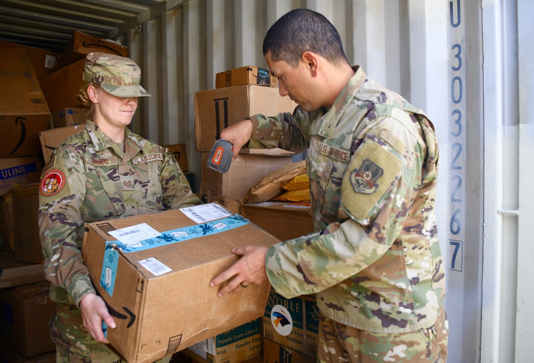 U.S. Air Force Tech Sgt. Jacqueline Bongard, 378 Expeditionary Contracting Squadron superintendent, presents a box for in processing at the mailroom on Prince Sultan Air Base, Kingdom of Saudi Arabia, Mach 10, 2020. Members of the 378 ECONS are responsible for soliciting and acquiring the services and materials needed for most construction projects and services on PSAB. (U.S. Air Force by Tech. Sgt. Michael Charles)