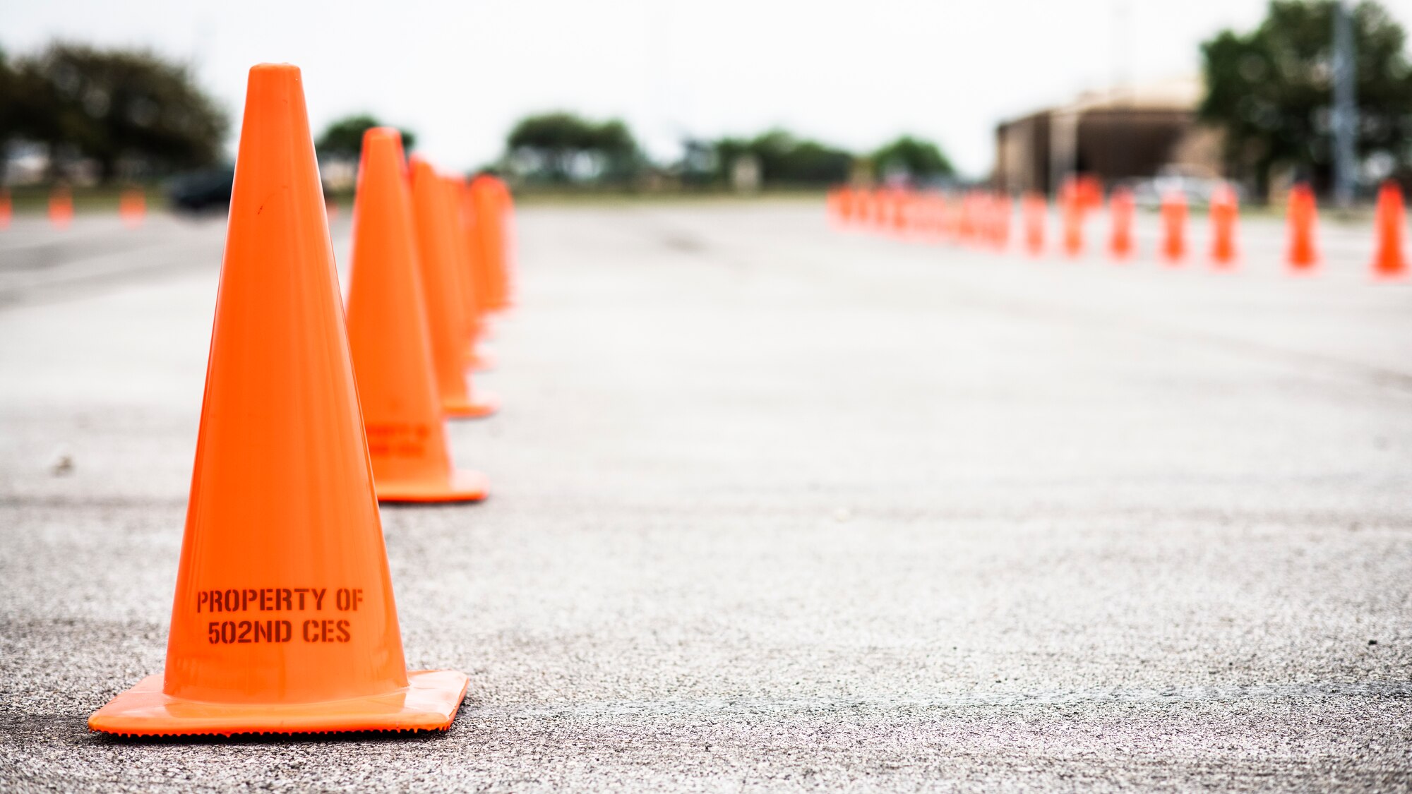 Cones are lined up March 19, 2020 in preparation for the opening of a drive-through screening and testing line beginning March 20, 2020 at Joint Base San Antonio-Lackland, Texas. The line will be open 9 a.m. to 2 p.m. Monday through Friday for anyone experiencing flu-like symptoms prior to entering Wilford Hall Ambulatory Surgical Center. (U.S. Air Force photo by Tech. Sgt. Katherine Spessa)