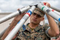 A U.S. Marine assembles a tent at the medical isolation and observation center (MIOC) being set up near the 13 Area on Camp Pendleton, California, March 15.