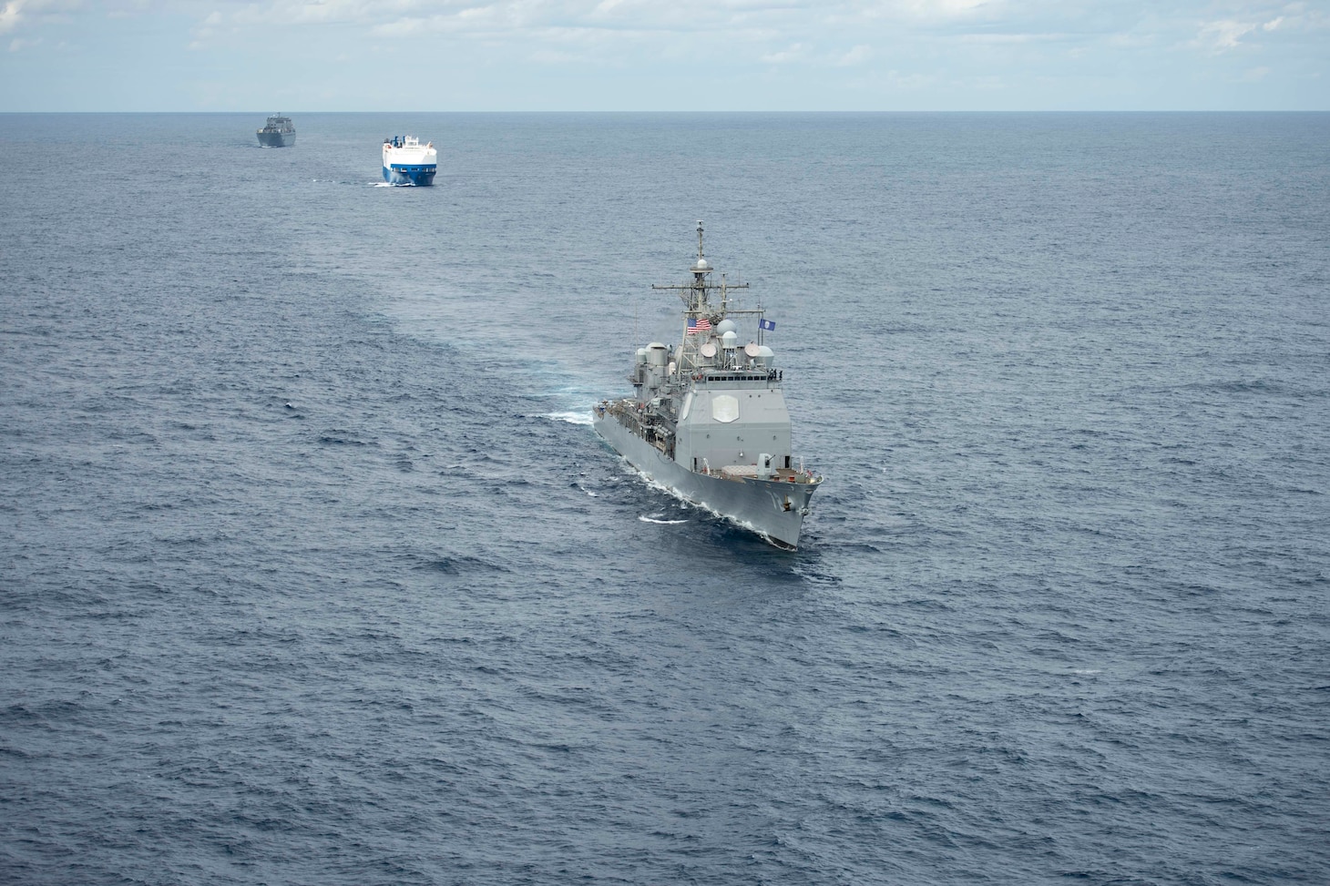 A convoy complied of the Ticonderoga-class guided-missile cruiser USS Vella Gulf (CG 72), right, MV Resolve, center, and USNS Benavidez (T-AKR 306) steam in formation.