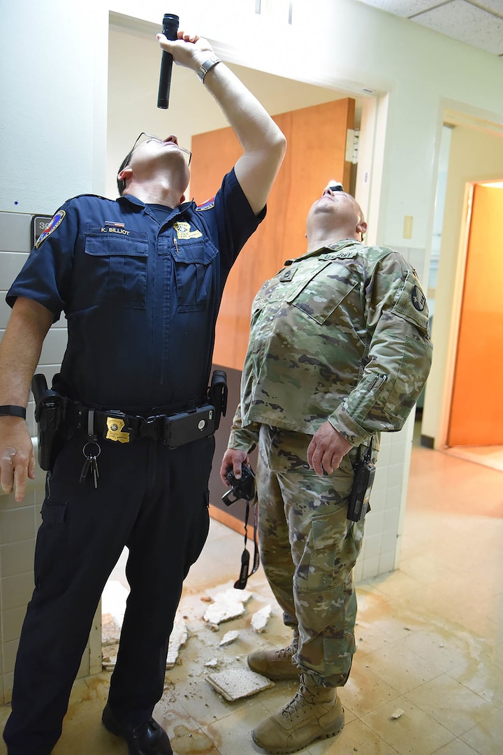 Louisiana Fire Marshal Lt. Kevin Billiot and Louisiana National Guard Sgt. 1st Class Clyde Batts examine the ceiling at the England Airpark Hospital in Alexandria, Louisiana, March 19, 2020. The Louisiana National Guard is helping state fire marshals and the Louisiana Department of Health assess buildings that could be used for patients during the COVID-19 crisis.
