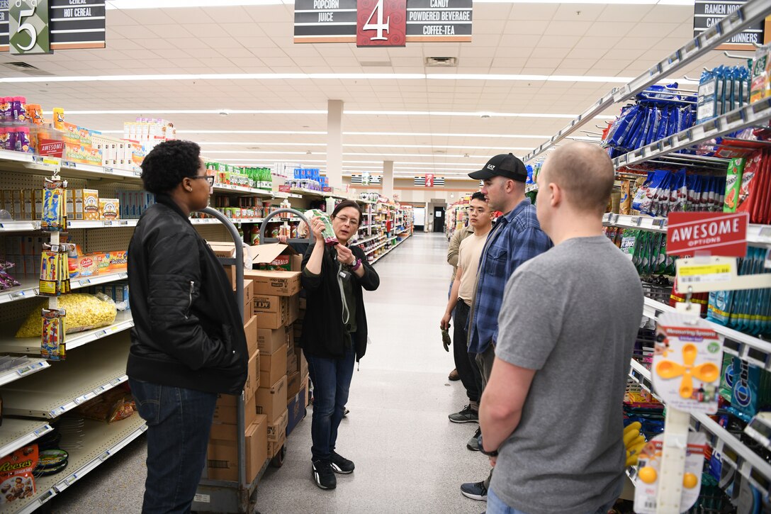 Dawn Thomas, Commissary assistant grocery manager, shows 11th Mission Support Group Airmen volunteers how to stock products at the Commissary at Joint Base Andrews, Md., Mar. 19, 2020. Anyone can volunteer to help restock shelves during the week from 6 p.m. to 10 p.m. (U.S Air Force photo by Airman 1st Class Spencer Slocum)