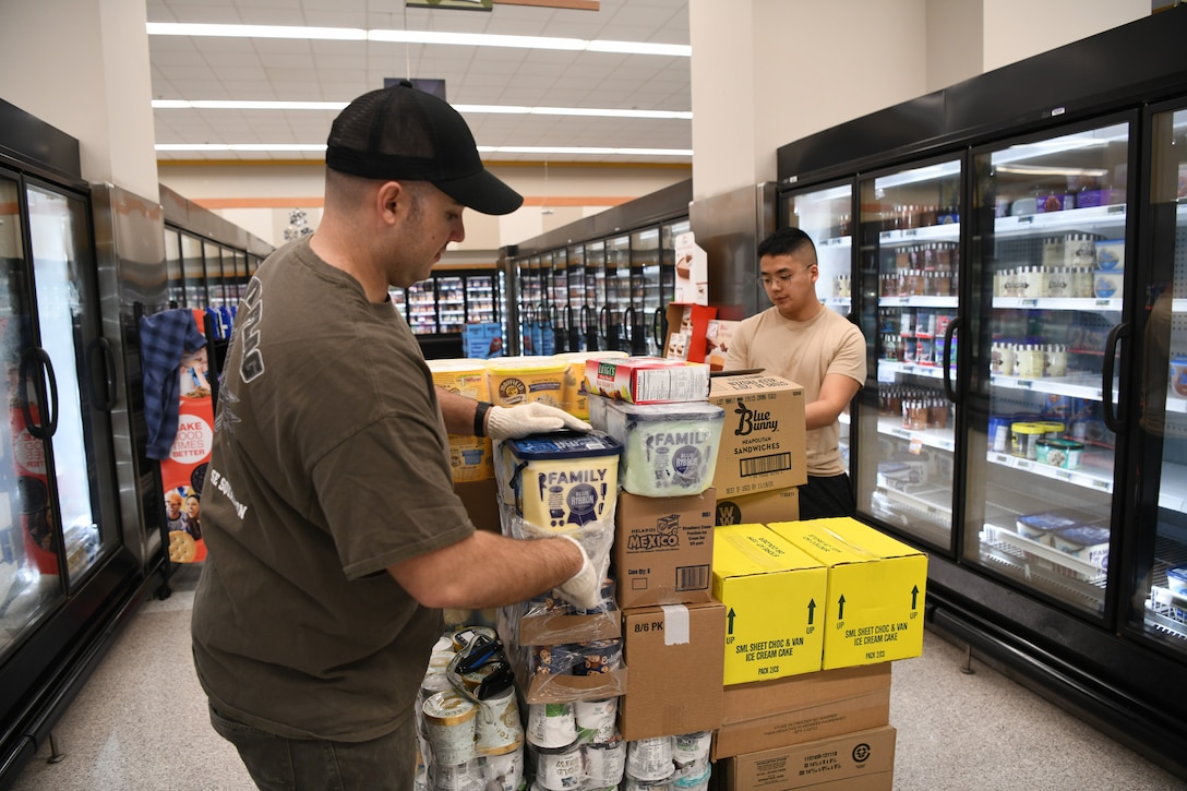 Technical Sgt. John Farmer, 11th Civil Engineer Squadron facilities maintenance non-commissioned officer in charge and Airman 1st Class Joshua Nguyen, 11th Logistics Readiness Squadron vehicle operations driver, unpack a pallet of frozen desserts at the Commissary at Joint Base Andrews, Md., Mar. 19, 2020. Seven Airmen from the 11th Mission Support Group volunteered their time to help restock shelves amidst the COVID-19 outbreak. (U.S. Air Force photo by Airman 1st Class Spencer Slocum)
