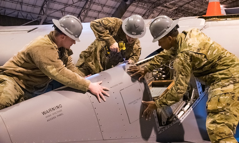 Senior Airman Brian Dawson and Airman 1st Class Quantavius Martin, 436th Maintenance Squadron aircraft maintenance journeymen, hold down a pylon panel as Senior Airman Mike Carlucci installs fasteners in the C-5M Galaxy Isochronal Inspection Dock at Dover Air Force Base, Del., March 17, 2020. The C-5M Galaxy Isochronal Inspection Dock keeps inventory of the largest aircraft in the Air Force. (U.S. Air Force photo by Roland Balik)