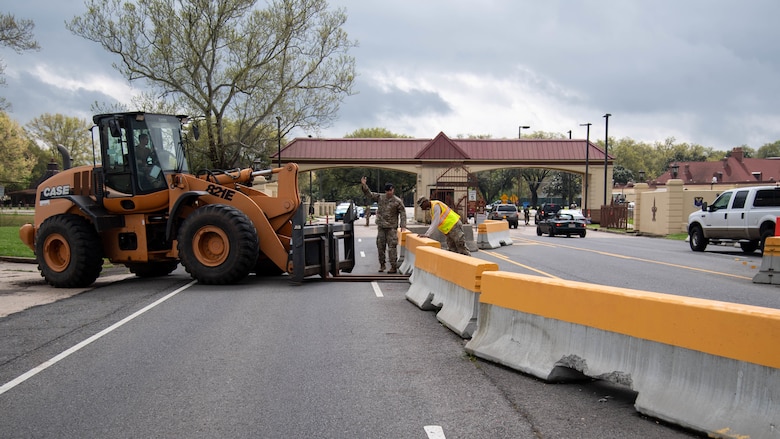 Airmen assigned to the 2nd Civil Engineer Squadron and the 2nd Security Forces Squadron rearrange barriers in front of the Bossier Gate at Barksdale Air Force Base, La., March 18, 2020. The Airmen opened Bossier Gate as the temporary entry control point to enter Barksdale AFB. (U.S. Air Force photo by Airman 1st Class Jacob B. Wrightsman)