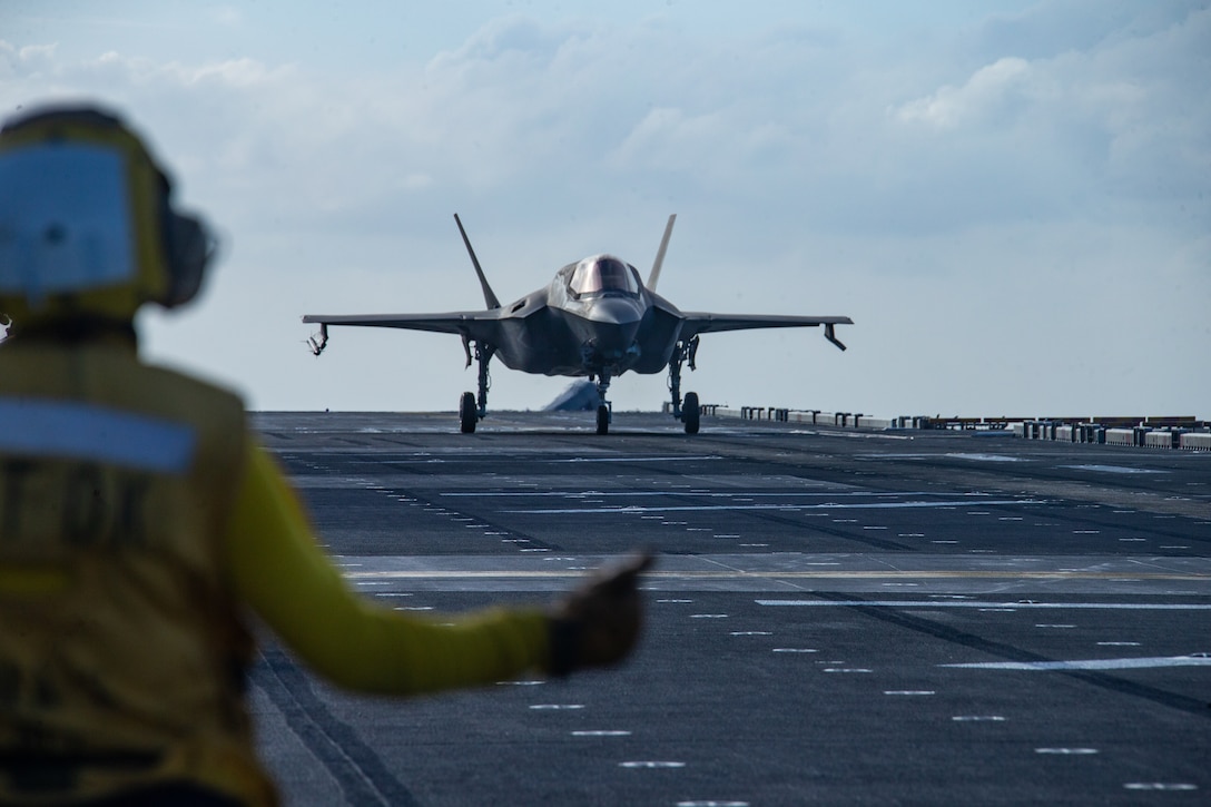 An F-35B Lightning II fighter aircraft is cleared for takeoff by a U.S. Sailor aboard amphibious assault ship USS America March 18.