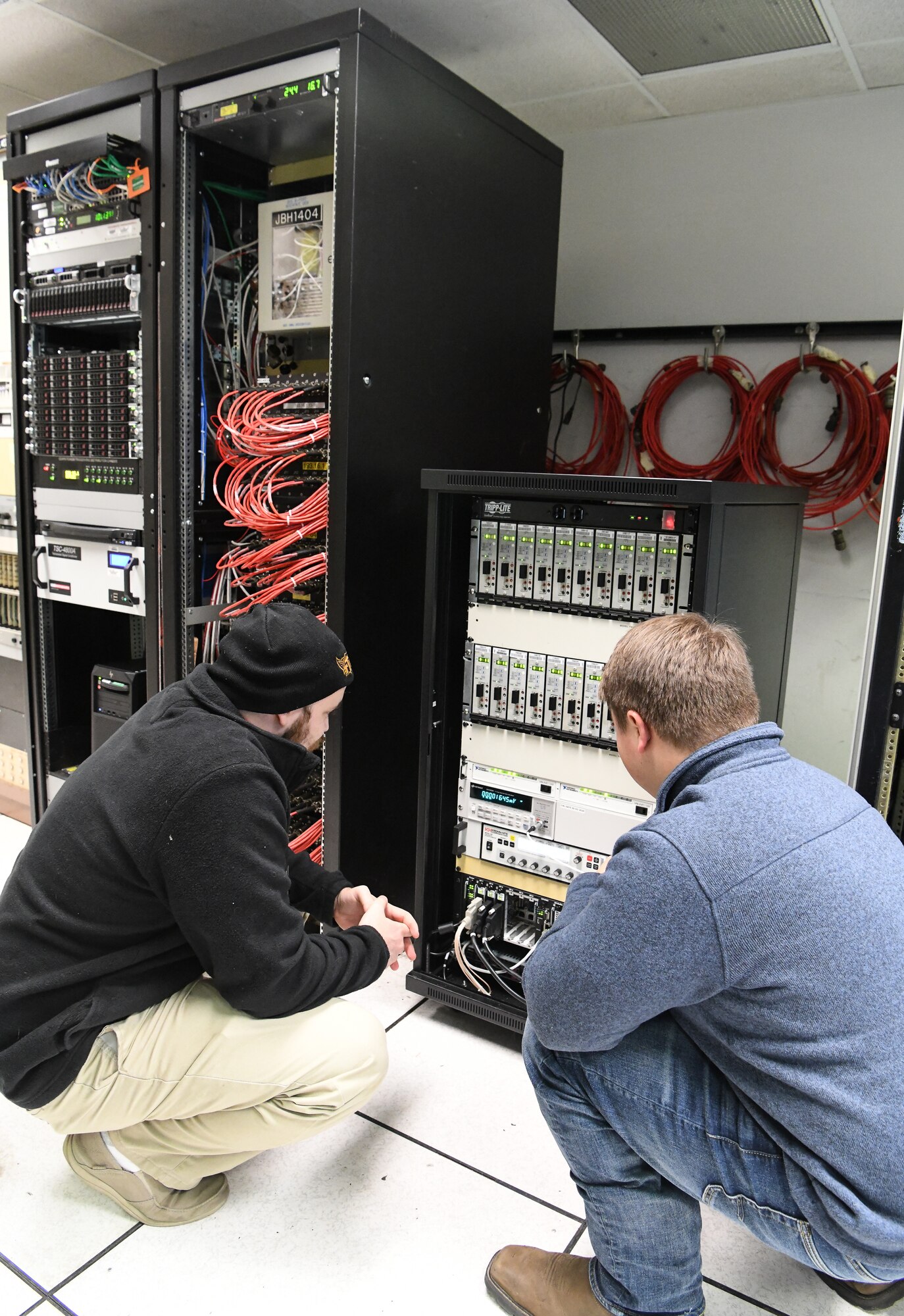 Dakota Aaron, left, an eSTARR hardware engineer, and Calvin Davis, an instrumentation, data and controls engineer, look at a portable data acquisition system in the Arnold Engineering Development Complex Engine Test Facility T-3 test cell data conditioning room at Arnold Air Force Base, Tenn., Dec. 3. The portable data acquisition system is part of an upgrade effort for the test cell, which includes the data source computers, left, and digital voltage scanners, center.  (U.S. Air Force photo by Jill Pickett)