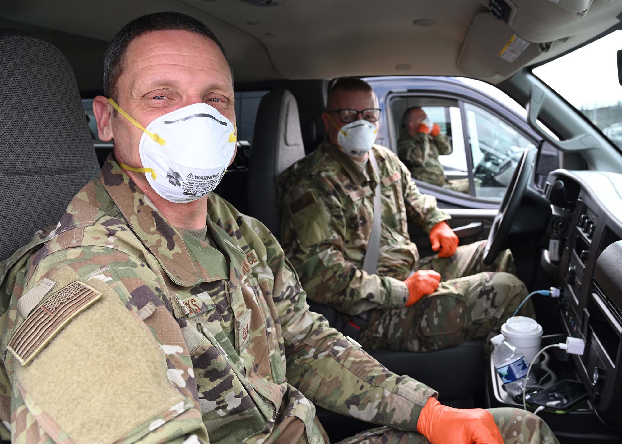 U.S. Air Force Tech. Sgt. Brian Hicks (Left) and U.S. Air Force Master Sgt. Richard Malloy, 175th Logistics Readiness Squadron, Maryland Air National Guard, wear medical personal protective equipment inside a van before transporting passengers from the Grand Princess cruise ship who have been quarantined due to the novel Coronavirus (COVID-19) pandemic, Baltimore, Md., March 17, 2020.