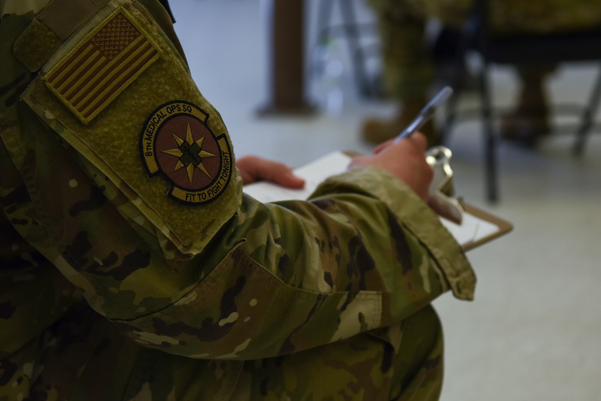 A U.S. Air Force Airman assigned to the 8th Medical Operations Squadron writes on a screening checklist in a COVID-19 screening room at Kunsan Air Base, Republic of Korea, March 19, 2020. The screening checklist consisted of questions pertaining to the service member’s recent travel history and any symptoms they may be experiencing prior to being seen by a provider. (U.S. Air Force photo by Senior Airman Jessica Blair)