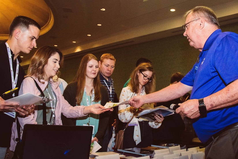 Man hands out brochures.