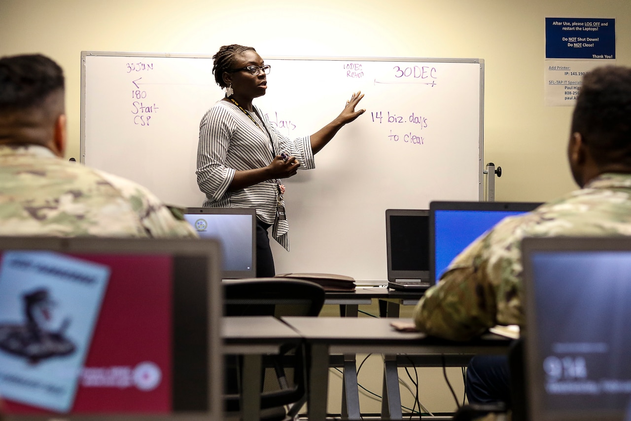 Teacher stands in front of a class.