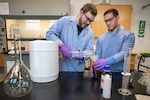 Code 134, Laboratory Division, chemists Anthony Painter, left, and Deniz Ferrin, right, make hand sanitizer March 20, 2020, inside the Puget Sound Naval Shipyard & Intermediate Maintenance Facility chem lab in Building 59. (PSNS & IMF photo by Scott Hansen)