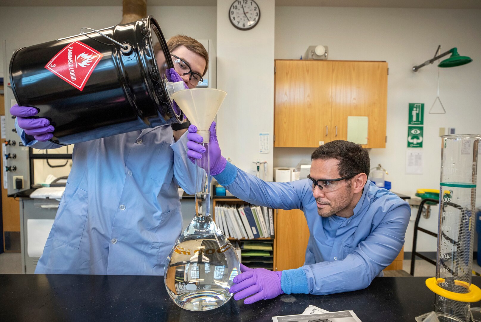 Code 134, Laboratory Division chemists Anthony Painter, left, and Deniz Ferrin, right, make hand sanitizer March 20, 2020, inside the Puget Sound Naval Shipyard & Intermediate Maintenance Facility chem lab in Building 59. (PSNS & IMF photo by Scott Hansen)