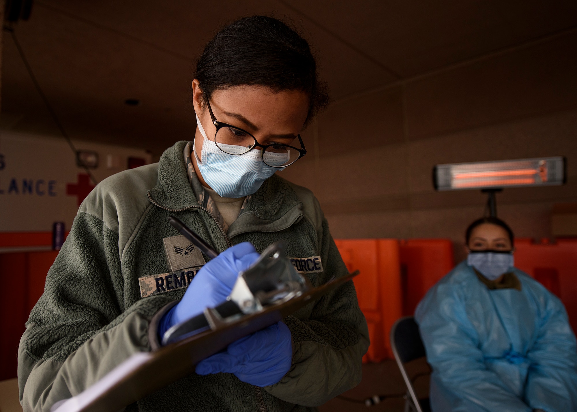 An Airman writes on a clipboard