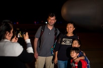 A family of passengers pose in front of a C-130 Hercules at Joint Base Charleston, S.C., March 20, 2020.