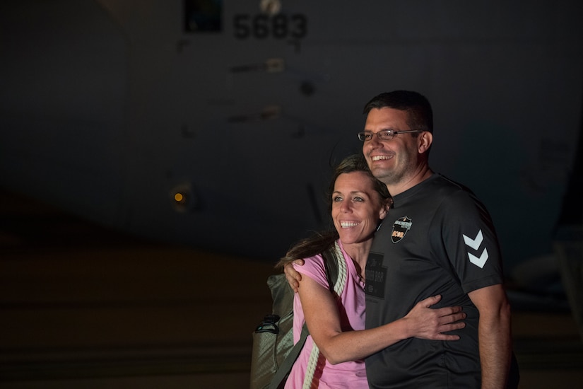 A family of passengers pose in front of a C-130 Hercules at Joint Base Charleston, S.C., March 20, 2020.