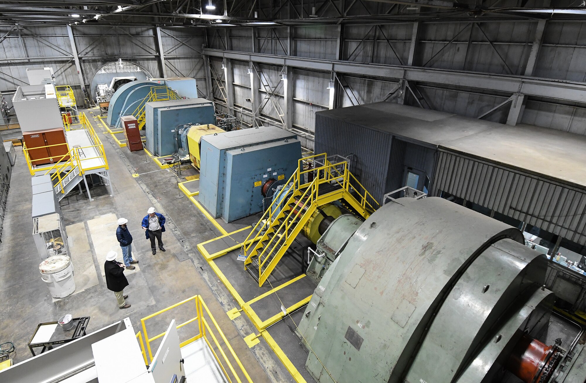 Tyler McCamey, a program manager, right, Ethan Jobe, a plant operations engineer, and Shelby Moorman, an electrical systems engineer, converse in the Main Drive building of the Arnold Engineering Development Complex (AEDC) Propulsion Wind Tunnel Facility Feb. 7, 2020, at Arnold Air Force Base, Tenn. AEDC team members determined a new configuration of the motors to power the compressors, resulting in a significant power savings. (U.S. Air Force photo by Jill Pickett)