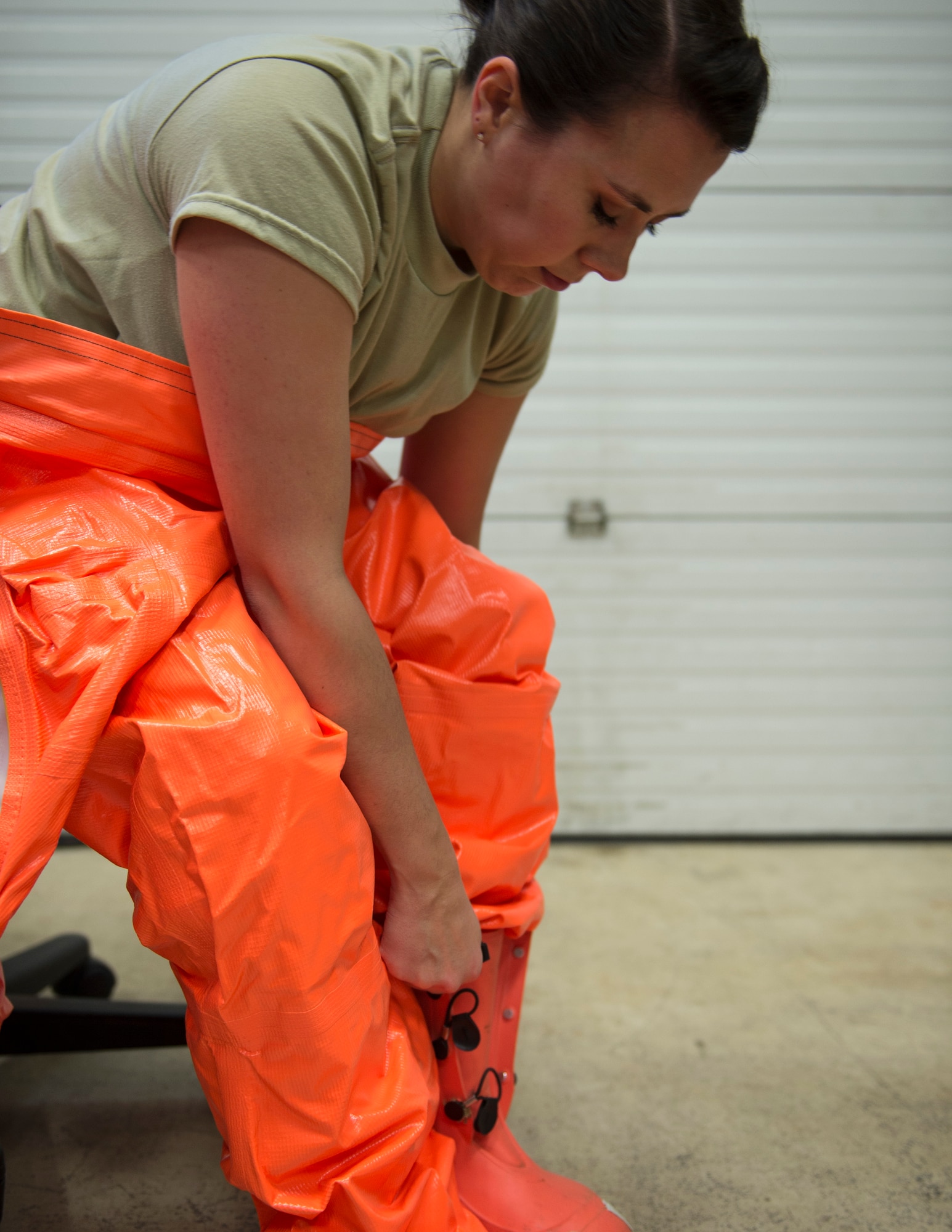 U.S. Air Force Senior Airman Morgan Johnson, an emergency manager with the 133rd Civil Engineer Squadron, puts on a HAZMAT suit in St. Paul, Minn., March 11, 2020.