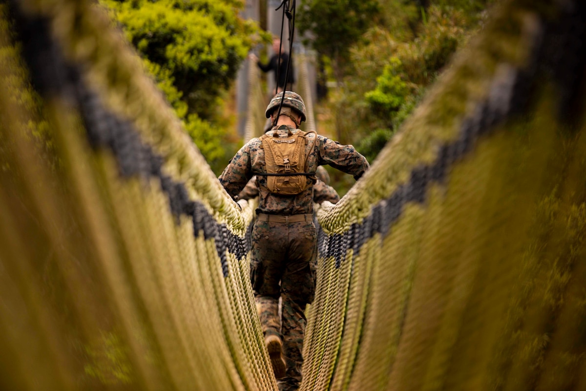 Marines cross a rope bridge.