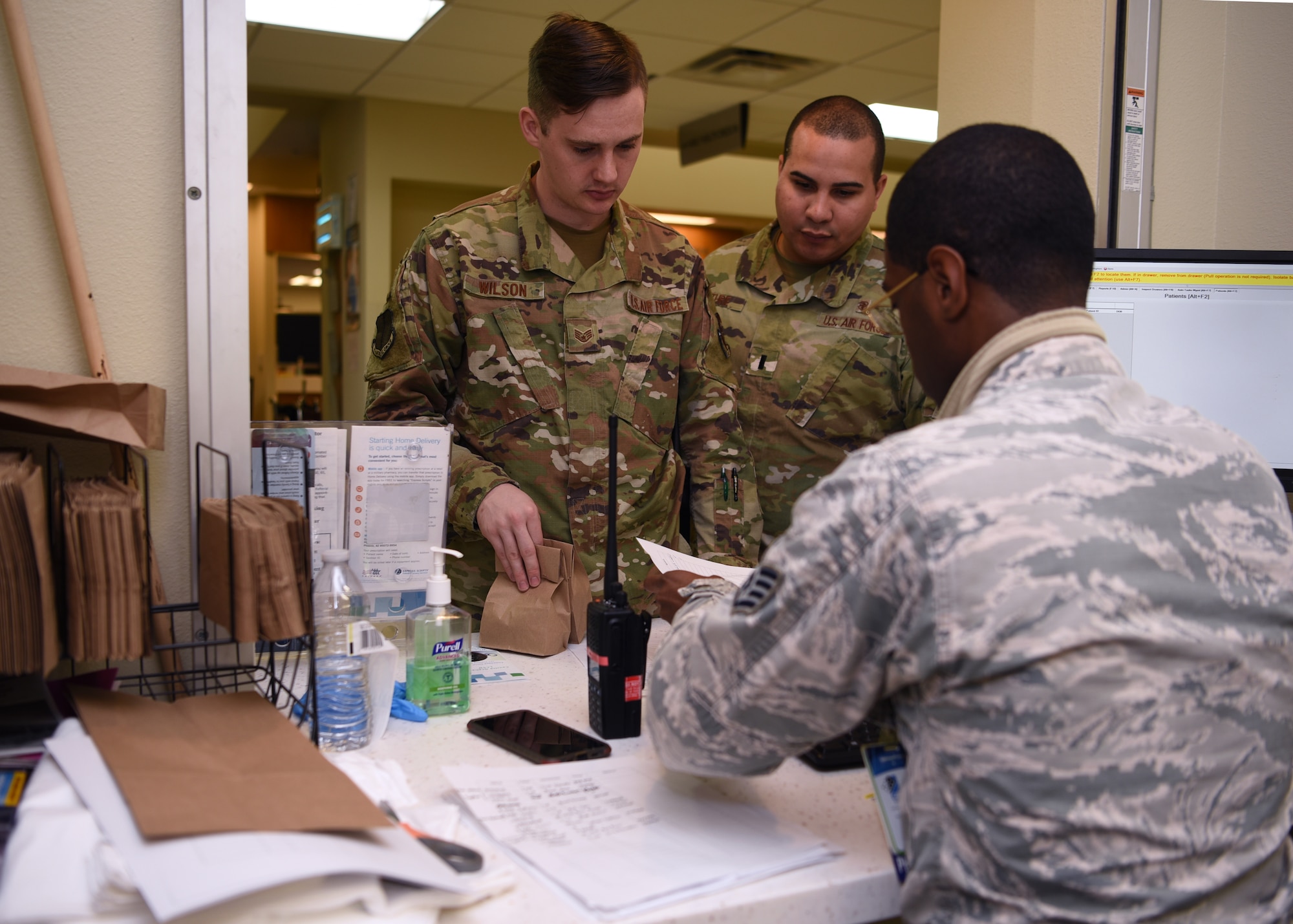 U.S. Air Force Staff Sgt. Sean Wilson, 17th Medical Group medical administration technician, collects a patient’s prescription at the Ross Clinic on Goodfellow Air Force Base, Texas, March 23, 2020. Since the 17th MDG activated a drive-in pharmacy to minimize personnel in the clinics, members from all departments in the clinic help deliver prescriptions to the patients in their cars. (U.S. Air Force Photo by Airman 1st Class Abbey Rieves)