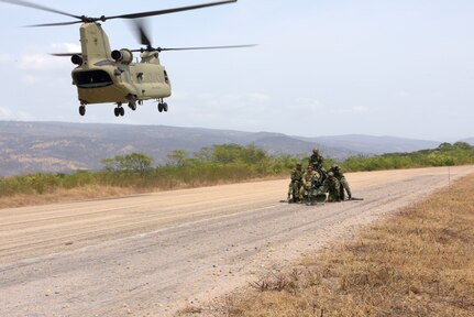 Colombian and U.S. service members prepare an M102 howitzer for sling load training as a  CH-47 Chinook from the 1st Battalion, 228th Aviation Regiment approaches at Fort Buenavista, Colombia, March 10, 2020. The operations were part of Exercise Vita, which brought combined forces together to perform humanitarian and civic-action operations in the La Guajira region of Colombia. Interoperability training allows participants to grow critical competencies while benefiting the Colombian people. (U.S. Air Force photo by Tech. Sgt. Daniel Owen)
