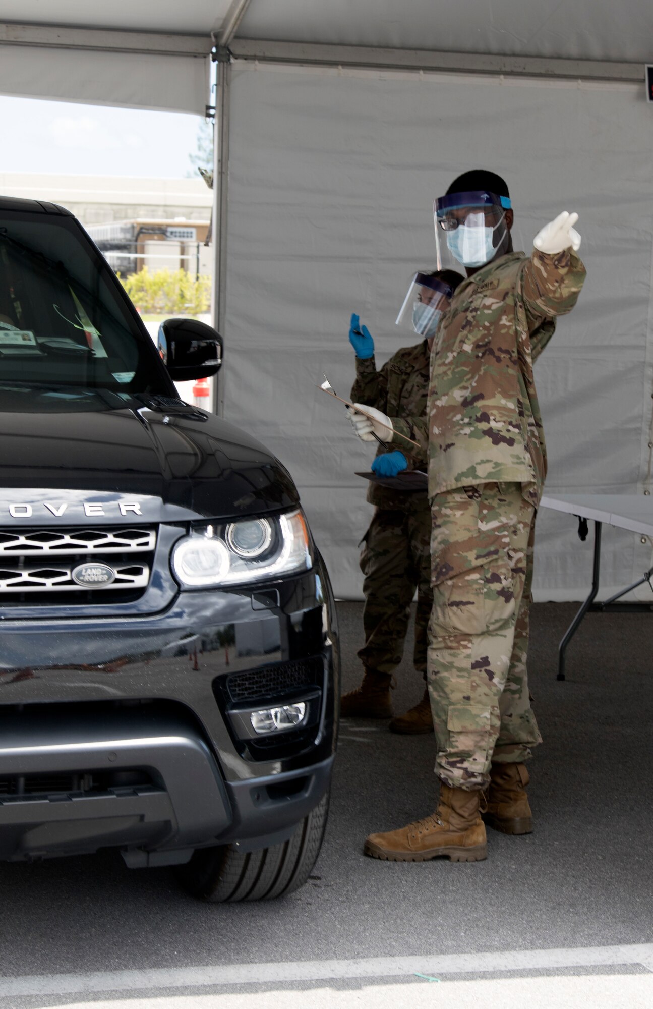 Florida Army National Guard Soldiers from the 1218th Transportation Company, West Palm Beach, scribe patient information during COVID-19 testing at Hard Rock Stadium in Miami Gardens March 23, 2020. The testing site is the second set up by the Guard in South Florida.