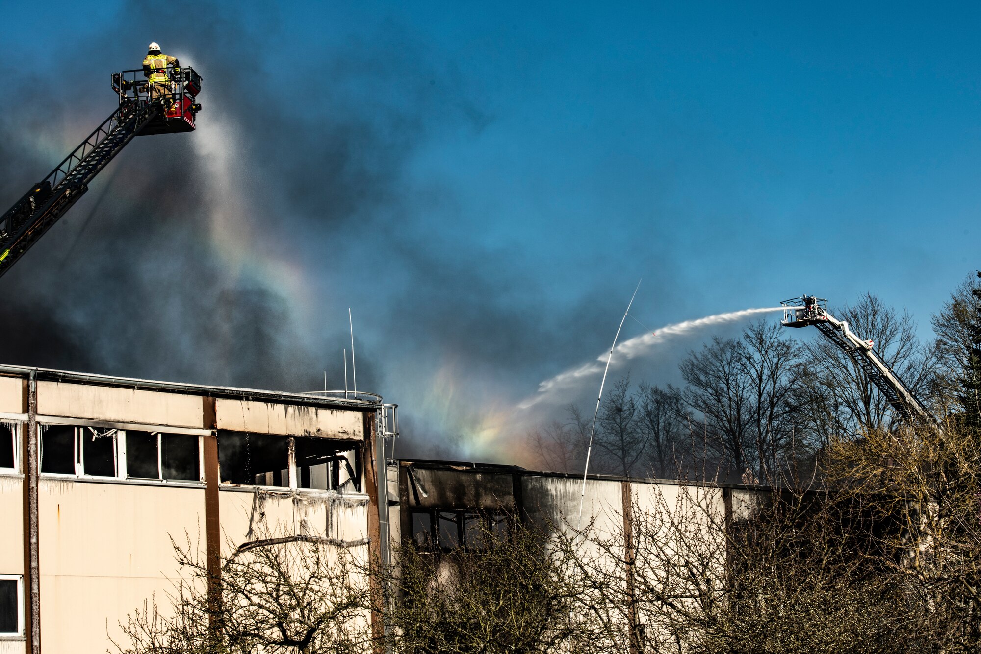 A German firefighter from Otterberg sprays water on a burning factory in Otterberg, Germany, March 23, 2020.