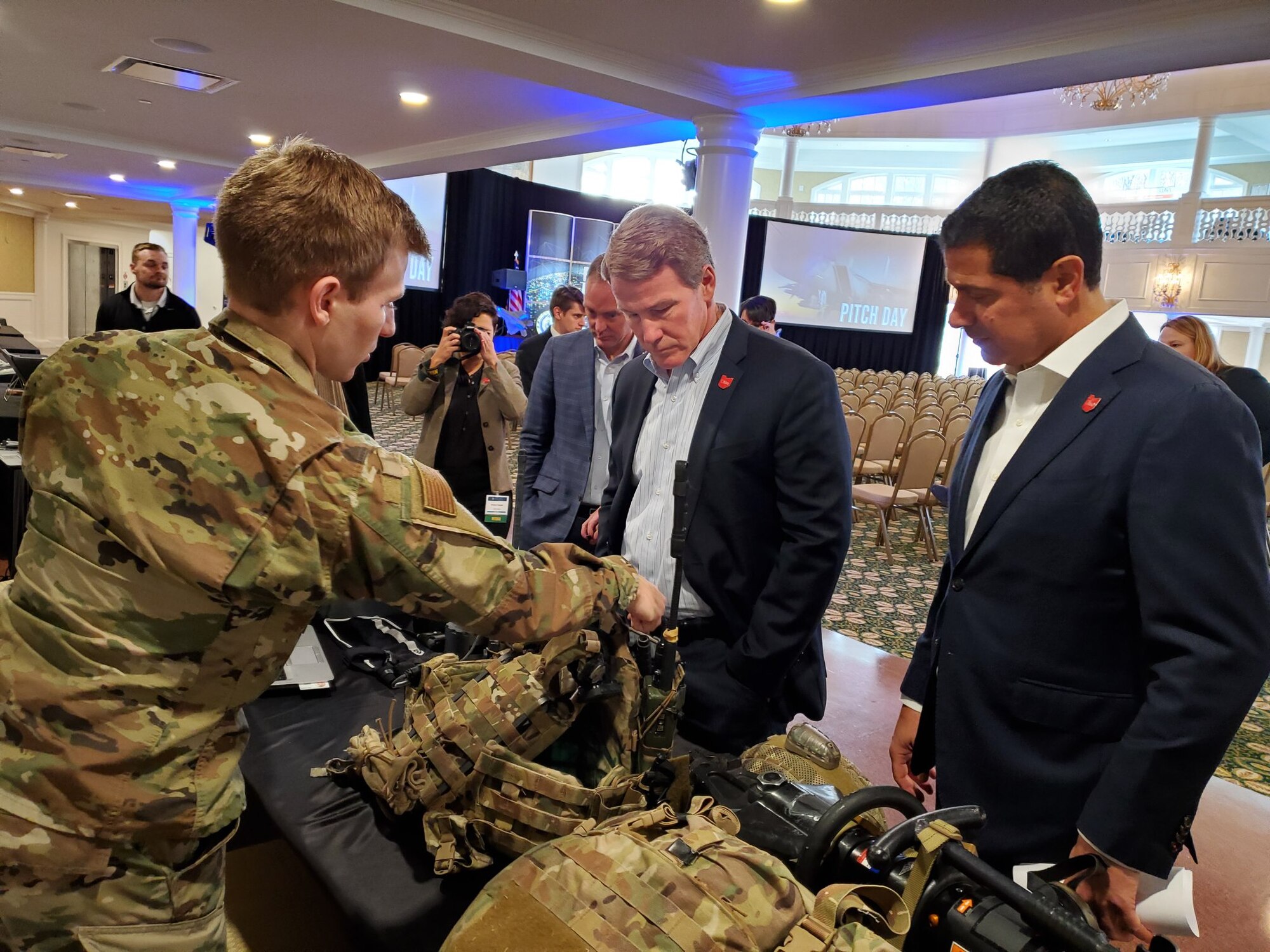 1st Lt Patrick Assef (left) a special warfare mechanical engineer with the Air Force Research Laboratory, explains several Air Force programs to Lt. Governor Jon Husted (center) of Ohio during the Air Force Life Cycle Management Center's Pitch Day Nov.13-14, 2019
