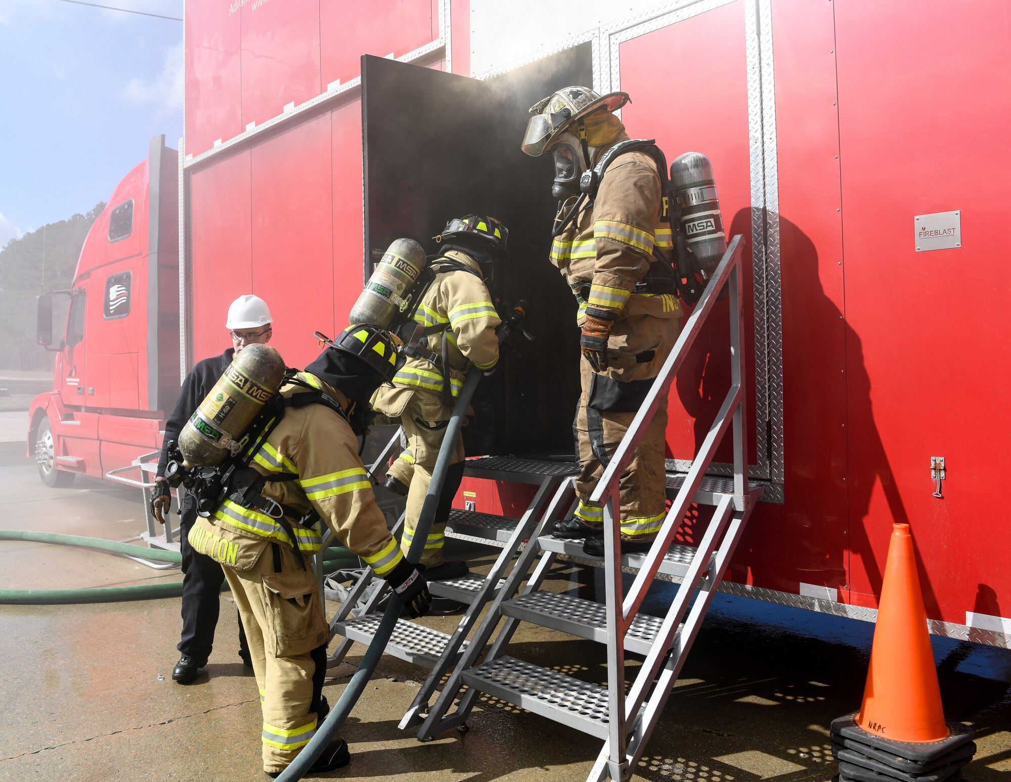 Arnold Air Force Base Fire and Emergency Services personnel enter a live fire trainer Feb. 25, 2020, at Arnold AFB, Tenn. during a training exercise. The trainer is a mobile trailer brought to the base for training. It uses propane for the fuel and simulated smoke, providing a more controllable situation for training. (U.S. Air Force photo by Jill Pickett)