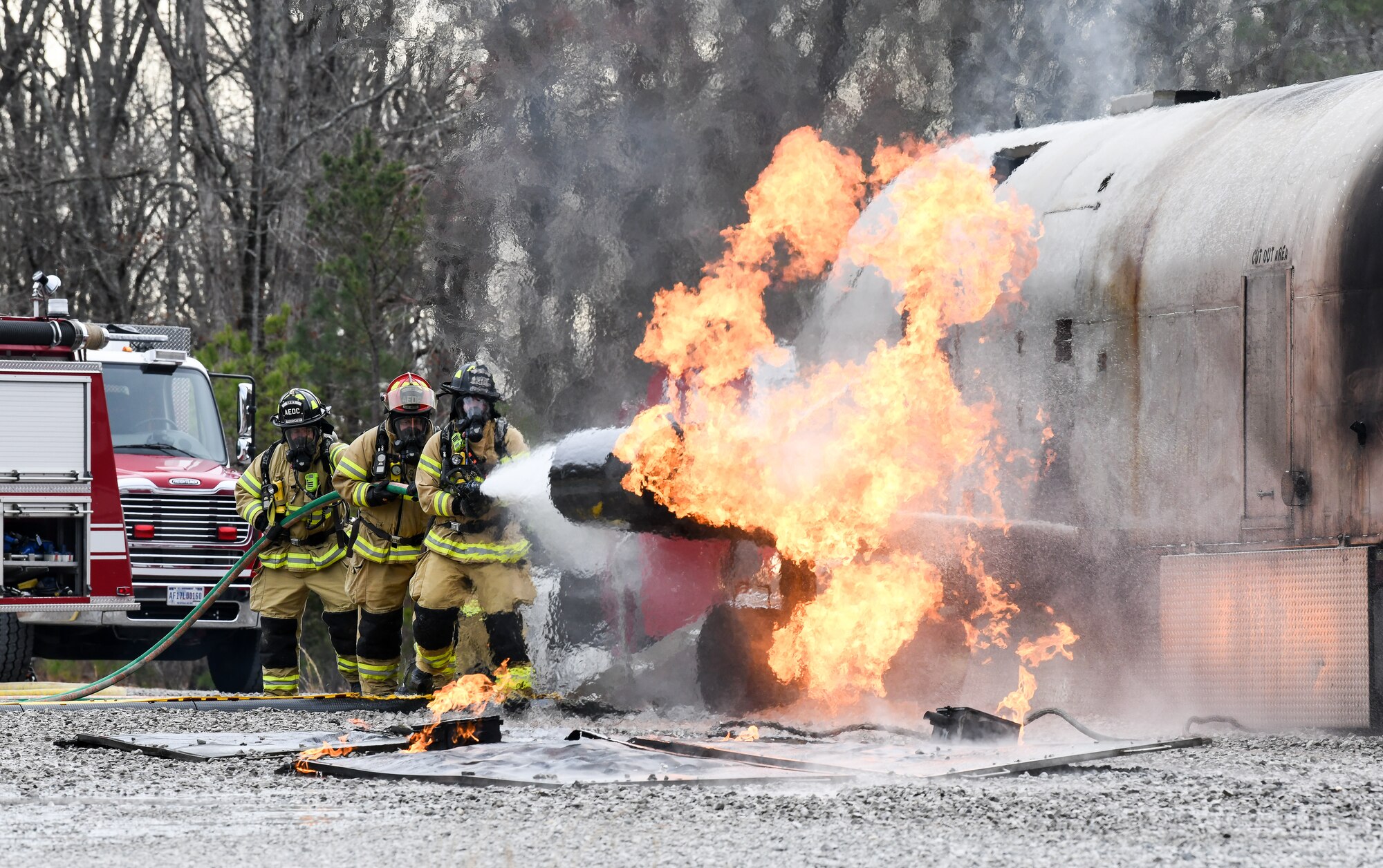 Arnold Air Force Base Fire and Emergency Services personnel attack an aircraft engine fire with a hand line while training, March 5, 2020, using a propane-fueled trainer brought to the base. The simulator, which was brought in to facilitate training, uses liquid and vapor propane to create controlled and repeatable fire scenarios. (U.S. Air Force photo by Jill Pickett)