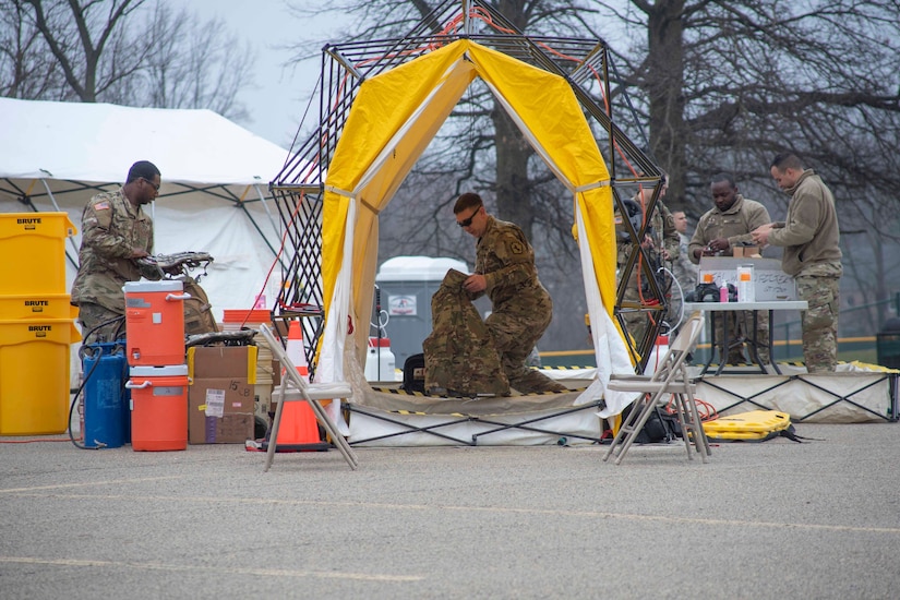 Airman set up a tent and tables.