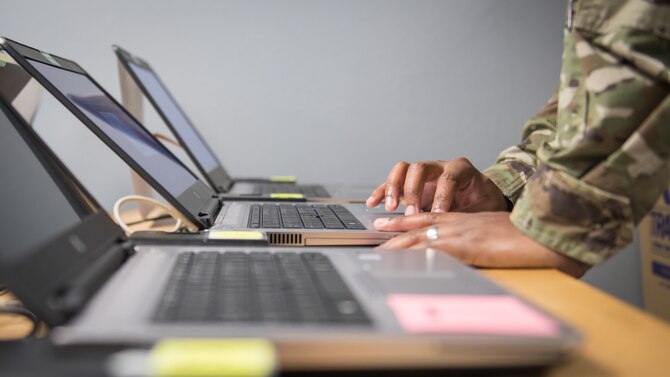 Staff Sgt. Kendall Armand, 2nd Communications Squadron client systems supervisor, looks over a laptop as it's being reimaged at Barksdale Air Force Base, La., March 20, 2020. Armand works at "The Hub," a walk-in computer clinic where Airmen from the 2nd CS work to install and fix various computer software issues. (U.S. Air Force photo by Tech. Sgt. Daniel Martinez)